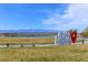 Community greenspace with mountain views in the distance, pond and community signage at 392 Canary Song Dr, Henderson, NV 89011