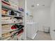 Bright laundry room with white washer, dryer and shelving filled with towels and laundry supplies at 392 Canary Song Dr, Henderson, NV 89011