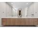 Modern bathroom featuring a double vanity with wood cabinets and a large frameless mirror at 40 Heron Harbour Dr, Henderson, NV 89011