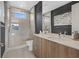 Modern bathroom with a glass enclosed shower, wood vanity, contemporary fixtures and light neutral tiling at 40 Heron Harbour Dr, Henderson, NV 89011