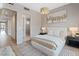 Well-lit bedroom with a neutral palette, plush bedding, and view into an ensuite bathroom at 40 Heron Harbour Dr, Henderson, NV 89011