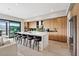 Modern kitchen featuring a waterfall island, barstool seating, and sleek wooden cabinets at 40 Heron Harbour Dr, Henderson, NV 89011