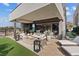 Inviting outdoor living space with a fireplace, plush seating, and views of the lush backyard and modern home at 40 Heron Harbour Dr, Henderson, NV 89011