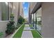 A modern side yard featuring pavers and turf between two homes, with a glimpse of the lake at 40 Heron Harbour Dr, Henderson, NV 89011