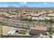 Aerial view of a home with a pool, artificial turf, and solar panels, in a neighborhood with mountain views at 4030 Midnight Crest Ave, North Las Vegas, NV 89031