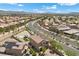 Aerial view showcasing a community with lush landscaping, pools, well-maintained roads, and mountain views at 4030 Midnight Crest Ave, North Las Vegas, NV 89031