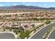 Aerial view of a community with homes, landscaping, mountains in the distance, and a swimming pool at 4030 Midnight Crest Ave, North Las Vegas, NV 89031