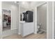 Hallway with light wood floors features a mini fridge and access to a bathroom and closet at 4030 Midnight Crest Ave, North Las Vegas, NV 89031