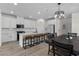 Open kitchen with white cabinets, an island with bar seating, and modern lighting at 4030 Midnight Crest Ave, North Las Vegas, NV 89031