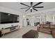 Open-concept living room with hardwood floors, a ceiling fan, and views into the kitchen at 4030 Midnight Crest Ave, North Las Vegas, NV 89031