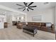 Spacious open-concept living room featuring hardwood floors and a large sectional sofa at 4030 Midnight Crest Ave, North Las Vegas, NV 89031