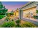 Lush backyard and patio featuring outdoor seating, vibrant flowers, and views into the home's interior at 4286 Pacifico Ln, Las Vegas, NV 89135
