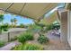 Landscaped backyard featuring retractable awnings, vibrant flowers, and views of the surrounding golf course at 4286 Pacifico Ln, Las Vegas, NV 89135