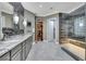 Modern bathroom featuring dual sinks, tile floors, and a large glass shower at 4286 Pacifico Ln, Las Vegas, NV 89135