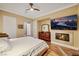 Cozy bedroom featuring a stone fireplace with mounted TV and wood floors at 4286 Pacifico Ln, Las Vegas, NV 89135