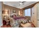 Cozy bedroom featuring beautiful furniture, a ceiling fan and a large window at 4286 Pacifico Ln, Las Vegas, NV 89135