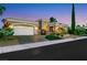 Beautiful single-story home featuring well-manicured landscaping, a spacious garage, and a brick driveway at dusk at 4286 Pacifico Ln, Las Vegas, NV 89135