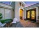 Stunning front porch with a wrought-iron door and a cozy seating area with a table and chairs at 4286 Pacifico Ln, Las Vegas, NV 89135