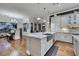 Kitchen island with a stainless steel sink, gray cabinets, and hardwood flooring, with a view to the dining area at 4286 Pacifico Ln, Las Vegas, NV 89135
