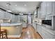 Bright kitchen featuring grey cabinets, granite countertops, stainless steel appliances, and hardwood flooring at 4286 Pacifico Ln, Las Vegas, NV 89135
