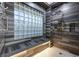 A modern shower featuring dark wood-look tiles, bench, and window block at 4286 Pacifico Ln, Las Vegas, NV 89135