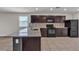 Spacious kitchen with a granite island, dark cabinetry, stainless steel appliances, and tile flooring at 4544 Velvet Oak Ct, Las Vegas, NV 89115