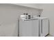 Laundry room featuring white washer and dryer appliances with overhead shelving for storage at 4544 Velvet Oak Ct, Las Vegas, NV 89115