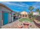 A fully landscaped backyard with an outdoor kitchen, artificial grass, covered patio and colorful mosaic table with benches at 4562 Sparwood Dr, Las Vegas, NV 89147