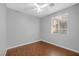 Cozy bedroom featuring wood floors, a ceiling fan, and a large window with blinds for natural light and privacy at 4562 Sparwood Dr, Las Vegas, NV 89147