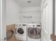 Laundry room with full size washer and dryer and wire shelving at 4562 Sparwood Dr, Las Vegas, NV 89147