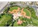 Overhead view of neighborhood baseball fields bordered by lush trees and green landscaping at 512 Los Dolces St, Las Vegas, NV 89138