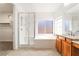 Bright bathroom featuring glass shower, soaking tub and wood vanity at 512 Los Dolces St, Las Vegas, NV 89138