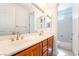 Bathroom with a double sink vanity, wood cabinets, and a large mirror at 512 Los Dolces St, Las Vegas, NV 89138