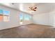 Bright bedroom with neutral carpet, windows offering an abundance of natural light, and a fan at 512 Los Dolces St, Las Vegas, NV 89138