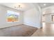 Bright living room showcasing neutral paint, carpeted floors and elegant archways to other rooms with window views at 512 Los Dolces St, Las Vegas, NV 89138