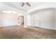 Bright living room featuring neutral paint, carpeted floors and elegant archways and access to stairs at 512 Los Dolces St, Las Vegas, NV 89138