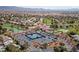 Aerial view featuring tennis courts, clubhouse, pond, and manicured landscaping at 5232 Saranac Rd, Las Vegas, NV 89130
