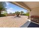 Desert landscaped backyard with palm trees, gravel, a covered patio, and a built-in grill at 5232 Saranac Rd, Las Vegas, NV 89130