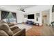 Comfortable living room with plush seating, hardwood floors, a ceiling fan, and a view to the front yard at 5236 Krista Alethea St, North Las Vegas, NV 89031