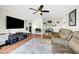 Open-concept living room with hardwood floors, modern furnishings, a ceiling fan and abundant natural light at 5236 Krista Alethea St, North Las Vegas, NV 89031