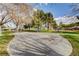 Community park with benches, picnic tables and a hopscotch court under mature trees on a sunny day at 5236 Krista Alethea St, North Las Vegas, NV 89031