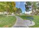 Well-maintained community park with walking path, picnic tables, benches, mature trees and green grass at 5236 Krista Alethea St, North Las Vegas, NV 89031