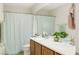 Full bathroom featuring double sinks, wood cabinets, and a shower with glass door at 5507 Gemini Bridges St, Las Vegas, NV 89130