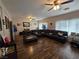 Bright living room with dark leather sofa, hardwood floors and ceiling fans at 5507 Gemini Bridges St, Las Vegas, NV 89130