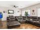 Comfortable living room with a large brown leather sectional sofa on dark hardwood flooring at 5507 Gemini Bridges St, Las Vegas, NV 89130