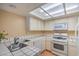 Efficient kitchen layout with tiled counters, white appliances, and abundant natural light at 5713 Whiteridge Ave, Las Vegas, NV 89107