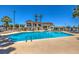 Community pool area with a clear blue swimming pool, palm trees, and a clubhouse, perfect for relaxation and recreation at 5713 Whiteridge Ave, Las Vegas, NV 89107