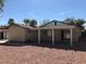 Back exterior view of house with covered patio and xeriscaping at 6196 W University Ave, Las Vegas, NV 89103