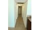Narrow hallway featuring tile flooring, neutral walls, and access to multiple rooms at 6196 W University Ave, Las Vegas, NV 89103