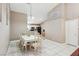 Bright dining area with white tile flooring, a dining table set for eight, and an open view to the kitchen at 628 Bay Bridge Dr, North Las Vegas, NV 89032